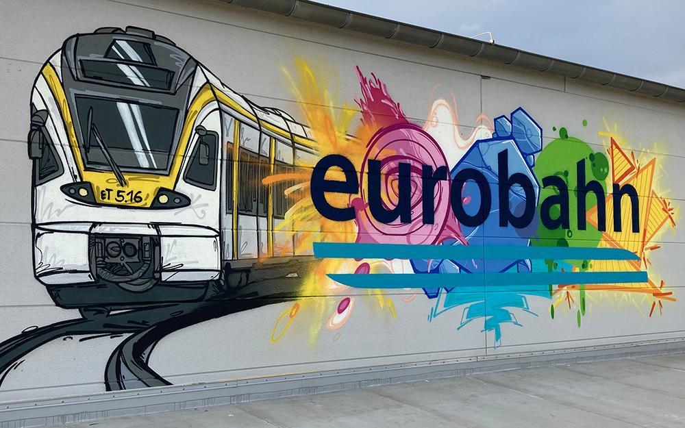 Werkstatt Hamm Graffiti Das offizielle eurobahn Graffiti bestehend aus einem Zug und dem eurobahn Logo auf einer Wand der Hammer Werkstatt.